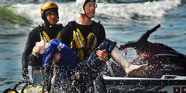 August 5: Surf rescue swimmer Doug Knutzen carries Dale Ostrander to the shore of the Cranberry Rd. beach approach in Long Beach, Wash. Rescue swimmers Eddie Mendez, left, and Will Green found Ostrander in the surf.