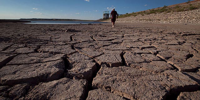 Aug. 7: Eddie Ray Roberts, superintendent of the city's waste and water department walks on the dried bed of Lake E.V. Spence in Robert Lee, Texas. After years of diminishing water supplies made even worse by the second most severe drought in state history, some communities are resorting to a plan that might have seemed absurd a generation ago: turning sewage into drinking water.