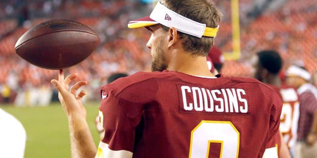Aug 7, 2014; Landover, MD, USA; Washington Redskins quarterback Kirk Cousins (8) spins a ball on his finger on the sidelines against the New England Patriots in the third quarter at FedEx Field. The Redskins won 23-6. Mandatory Credit: Geoff Burke-USA TODAY Sports