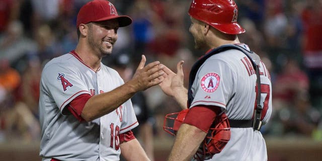 Jul 5, 2015; Arlington, TX, USA; Los Angeles Angels relief pitcher Huston Street (16) and catcher Chris Iannetta (17) celebrate the win over the Texas Rangers at Globe Life Park in Arlington. The Angels defeated the Rangers 12-6. Mandatory Credit: Jerome Miron-USA TODAY Sports