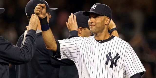 Aug 8, 2014; Bronx, NY, USA; New York Yankees shortstop Derek Jeter (2) celebrates with teammates after defeating the Cleveland Indians 10-6 at Yankee Stadium. Mandatory Credit: Adam Hunger-USA TODAY Sports