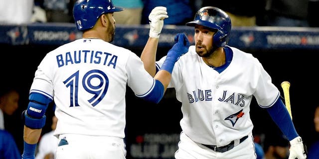 Aug 11, 2015; Toronto, Ontario, CAN; Toronto Blue Jays right fielder Jose Bautista (19) is greeted by designated hitter Chris Colabello (15) after hitting a home run against Oakland Athletics in the fifth inning at Rogers Centre. Mandatory Credit: Dan Hamilton-USA TODAY Sports