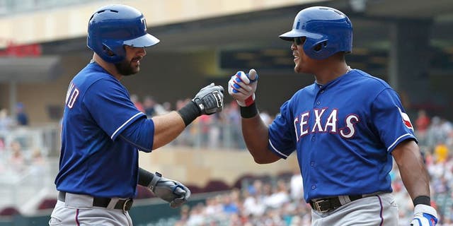 Texas Rangersâ Mitch Moreland, left, is congratulated by Adrian Beltre following his two-run home run off Minnesota Twins pitcher Ervin Santana in the fourth inning of a baseball game, Thursday, Aug. 13, 2015, in Minneapolis. (AP Photo/Jim Mone)