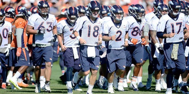 Aug 12, 2015; Englewood, CO, USA; Denver Broncos quarterback Peyton Manning (18), guard Ben Garland (63), quarterback Zac Dysert (2) and quarterback Brock Osweiler (17) warm up during training camp activities at the UCHealth Training Center. Mandatory Credit: Ron Chenoy-USA TODAY Sports