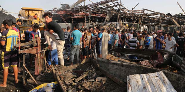Aug. 13, 2015: Civilians gather at the scene of bomb attack in Jameela market in the Iraqi capital's crowded Sadr City neighborhood Baghdad, Iraq.