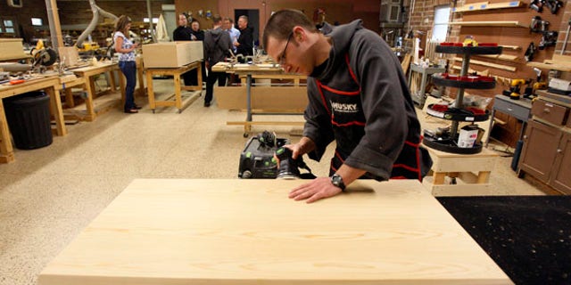 Aug. 12: Benedictine Novice Joseph Eichorn sands a casket lid in a workshop at St. Joseph Abbey in Covington, La.