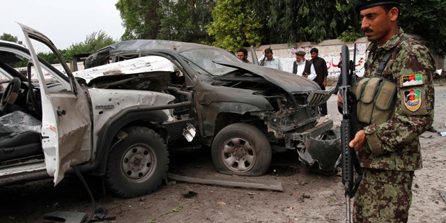 Aug. 2, 2010: Afghans gather at the scene of an attack on a presidential adviser in Jalalabad, east of Kabul, Afghanistan. Militants attacked the second government official in the east on the same day.