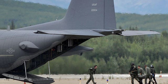 Aug. 14: In this photo provided by Bill Minnix, rescuers from the Alaska Air National Guard carry one of the plane crash victims to a waiting HC-130 at the McGrath airport in Kuskokwim, Alaska, about 225 miles northwest of Anchorage