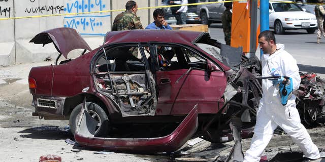 Aug. 15, 2016: An Afghan security personnel inspects the site of an explosion near the U.S. Embassy in Kabul, Afghanistan.