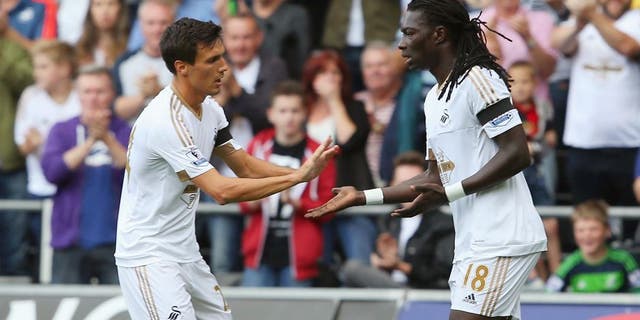 SWANSEA, WALES - AUGUST 15: Bafetimbi Gomis of Swansea City celebrates scoring his team's first goal with his team mate Jack Cork during the Barclays Premier League match between Swansea City and Newcastle United at Liberty Stadium on August 15, 2015 in Swansea, United Kingdom. (Photo by Jan Kruger/Getty Images)