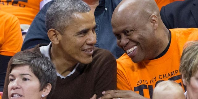 Barack Obama (L) sits beside his brother-in-law Craig Robinson while attending the Green Bay versus Princeton women's college basketball game (Photo by MIchael Reynolds-Pool/Getty Images)