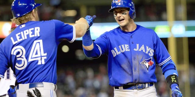 Aug 25, 2015; Arlington, TX, USA; Toronto Blue Jays shortstop Troy Tulowitzki (2) celebrates with first base coach Tim Leiper (34) after hitting the game tying single against the Texas Rangers during the ninth inning at Globe Life Park in Arlington. Mandatory Credit: Kevin Jairaj-USA TODAY Sports