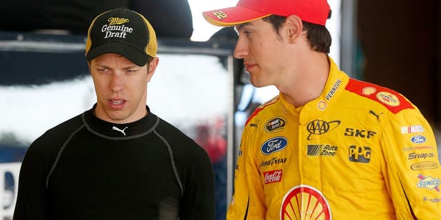 BROOKLYN, MI - AUGUST 15: (R-L) Joey Logano, driver of the #22 Shell Pennzoil Ford, and Brad Keselowski, driver of the #2 Miller Lite Ford, talk in the garage during practice for the NASCAR Sprint Cup Series Pure Michigan 400 at Michigan International Speedway on August 15, 2015 in Brooklyn, Michigan. (Photo by Brian Lawdermilk/NASCAR via Getty Images)