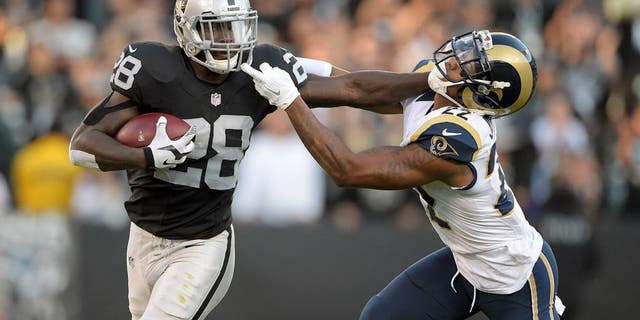 Aug 14, 2015; Oakland, CA, USA; Oakland Raiders running back Latavius Murray (28) stiff arms St. Louis Rams corneramback Tremaine Johnson (22) in a preseason NFL football game at O.co Coliseum. Mandatory Credit: Kirby Lee-USA TODAY Sports