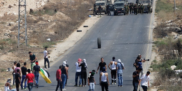 August 15, 2014: Palestinian protesters face Israeli soldiers during clashes near the West Bank city of Nablus. (AP)