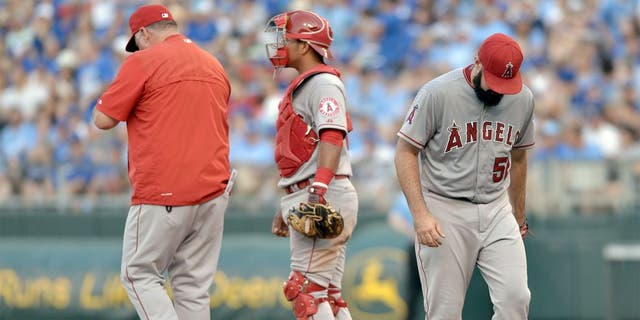 Aug 15, 2015; Kansas City, MO, USA; Los Angeles Angels manager Mike Scioscia (14) comes to the mound to relieve starting pitcher Matt Shoemaker (52) in the second inning against the Kansas City Royals at Kauffman Stadium. Mandatory Credit: Denny Medley-USA TODAY Sports