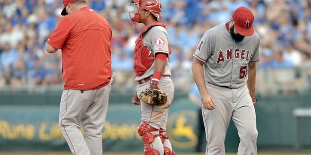 Aug 15, 2015; Kansas City, MO, USA; Los Angeles Angels manager Mike Scioscia (14) comes to the mound to relieve starting pitcher Matt Shoemaker (52) in the second inning against the Kansas City Royals at Kauffman Stadium. Mandatory Credit: Denny Medley-USA TODAY Sports