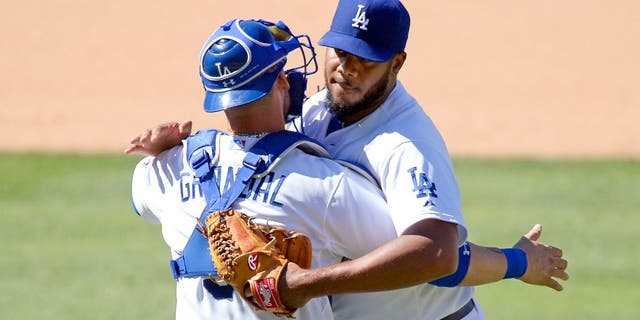 LOS ANGELES, CA - AUGUST 16: Closer Kenley Jansen #74 and catcher Yasmani Grandal #9 of the Los Angeles Dodgers celebrate after defeating the Cincinnati Reds, 2-1, at Dodger Stadium August 16, 2015, in Los Angeles, California. (Photo by Kevork Djansezian/Getty Images)
