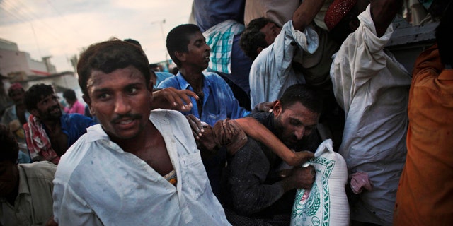 Aug. 17: Pakistanis displaced by flooding grab a bag of food aid as they crowd during a distribution on the road near the flood line outside of Sukkur, in Sindh province, southern Pakistan.