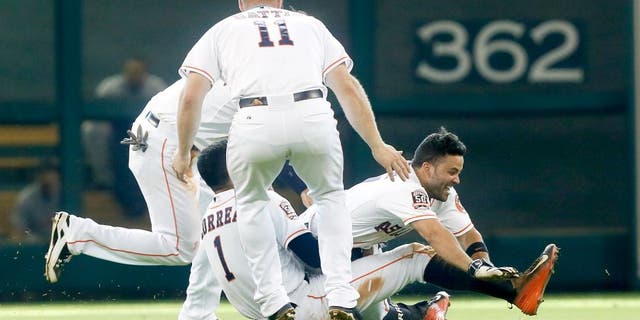 HOUSTON, TX - AUGUST 16: Jose Altuve #27 of the Houston Astros celebrates with Carlos Correa, Evan Gattis #11 and Jake Marisnick #6 after hitting walkoff single to beat the Detroit Tigers 6-5 at Minute Maid Park on August 16, 2015 in Houston, Texas. (Photo by Bob Levey/Getty Images)