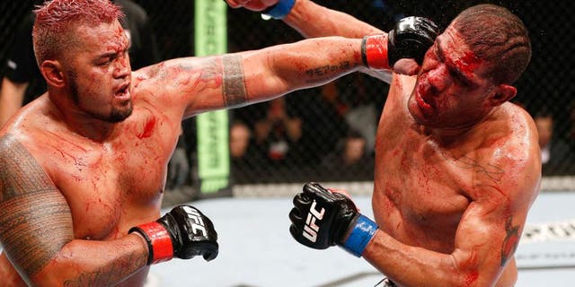 BRISBANE, AUSTRALIA - DECEMBER 07: (L-R) Mark Hunt punches Antonio "Bigfoot" Silva in their heavyweight fight during the UFC Fight Night event at the Brisbane Entertainment Centre on December 7, 2013 in Brisbane, Australia. (Photo by Josh Hedges/Zuffa LLC/Zuffa LLC via Getty Images)