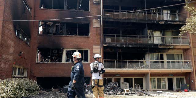 FILE - In this Thursday, Aug. 11, 2016, file photo, emergency personnel view the scene of an apartment building fire in Silver Spring, Md.