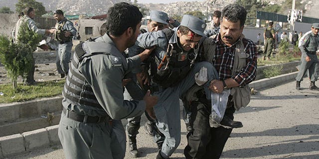 August 19: Afghan security forces carry a wounded police man at the site of a suicide attack outside The British Council in Kabul, Afghanistan.