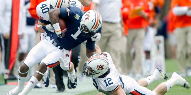 AUBURN, AL - APRIL 19: Linebacker Daniel Pond #40 and defensive back Mack VanGorder #12 of the Auburn Tigers attempts to tackle wide receiver D'haquille Williams #1 of the Auburn Tigers during Auburn's A-Day game on April 19, 2014 at Jordan-Hare Stadium in Auburn, Alabama. The blue team defeated the white team 58-3. (Photo by Michael Chang/Getty Images)