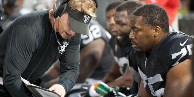 Aug 28, 2014; Oakland, CA, USA; Oakland Raiders defensive coordinator Jason Tarver speaks with defensive end Shelby Harris (75) during the third quarter of the game against the Seattle Seahawks at O.co Coliseum. Mandatory Credit: Ed Szczepanski-USA TODAY Sports