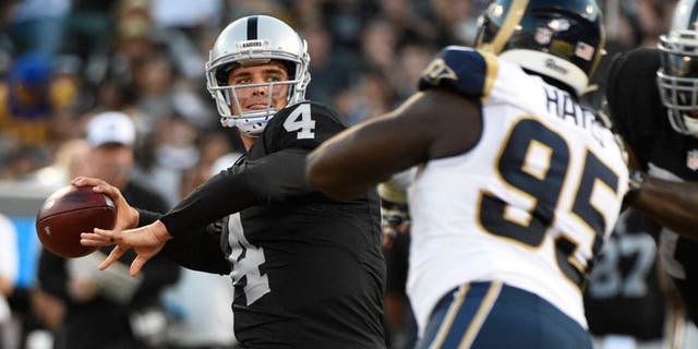 August 14, 2015; Oakland, CA, USA; Oakland Raiders quarterback Derek Carr (4) passes the football against St. Louis Rams defensive end William Hayes (95) during the first quarter in a preseason NFL football game at O.co Coliseum. Mandatory Credit: Kyle Terada-USA TODAY Sports