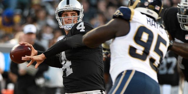 August 14, 2015; Oakland, CA, USA; Oakland Raiders quarterback Derek Carr (4) passes the football against St. Louis Rams defensive end William Hayes (95) during the first quarter in a preseason NFL football game at O.co Coliseum. Mandatory Credit: Kyle Terada-USA TODAY Sports