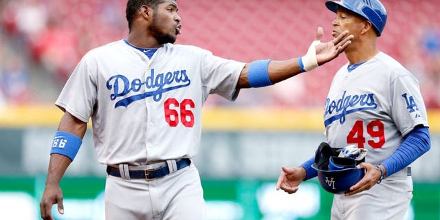 CINCINNATI, OH - JUNE 9: Yasiel Puig #66 of the Los Angeles Dodgers talks to third base coach Lorenzo Bundy during the game against the Cincinnati Reds at Great American Ball Park on June 9, 2014 in Cincinnati, Ohio. The Dodgers won 6-2. (Photo by Joe Robbins/Getty Images) *** Local Caption *** Yasiel Puig;Lorenzo Bundy