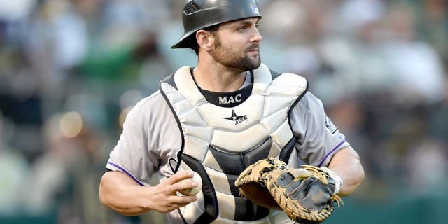 OAKLAND, CA - JUNE 30: Michael McKenry #8 of the Colorado Rockies turns to check the base runner after catching a foul pop-up off the bat of Billy Butler #16 of the Oakland Athletics in the bottom of the fourth inning at O.co Coliseum on June 30, 2015 in Oakland, California. (Photo by Thearon W. Henderson/Getty Images)