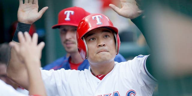 Aug 17, 2015; Arlington, TX, USA; Texas Rangers right fielder Shin-Soo Choo (17) is congratulated by his teammates in the dugout after scoring a run in the first inning against the Seattle Mariners at Globe Life Park in Arlington. Mandatory Credit: Tim Heitman-USA TODAY Sports