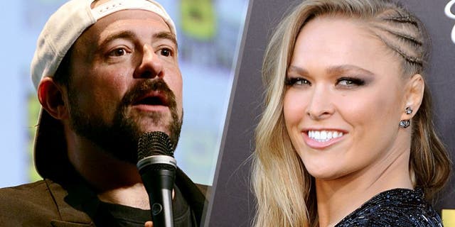 SAN DIEGO, CA - JULY 10: Filmmaker Kevin Smith speaks onstage at the 'Yoga Hosers' panel during Comic-Con International 2015 at the San Diego Convention Center on July 10, 2015 in San Diego, California. (Photo by Albert L. Ortega/Getty Images) WESTWOOD, CA - JUNE 01: Ronda Rousey arrives at Warner Bros. Pictures Premiere of 'Entourage' at Regency Village Theatre on June 1, 2015 in Westwood, California. (Photo by Barry King/Getty Images)
