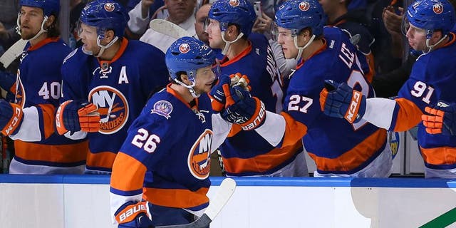 Mar 13, 2015; Uniondale, NY, USA; New York Islanders center Tyler Kennedy (26) high fives the bench after scoringg during the third period against the Ottawa Senators at Nassau Veterans Memorial Coliseum. Ottawa Senators won 2-1. Mandatory Credit: Anthony Gruppuso-USA TODAY Sports