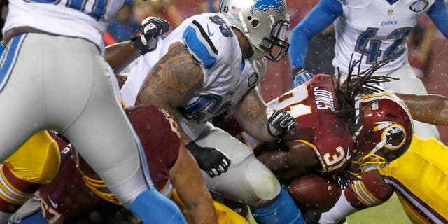 Washington Redskins running back Matt Jones (31) dives past Detroit Lions defensive tackle Jermelle Cudjo (63) to score a touchdown during the first half of an NFL preseason football game, Thursday, Aug. 20, 2015, in Landover, Md. (AP Photo/Alex Brandon)