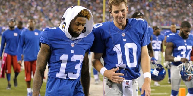 New York Giants quarterback Eli Manning (10) and Odell Beckham (13) talk while walking off the field after the first half of a preseason NFL football game against the Jacksonville Jaguars, Saturday, Aug. 22, 2015, in East Rutherford, N.J. (AP Photo/Bill Kostroun)
