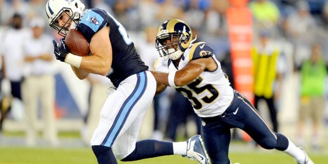 Aug 23, 2015; Nashville, TN, USA; Tennessee Titans tight end Chase Coffman (85) catches a touchdown pass while being defended by St. Louis Rams safety Jay Hughes (35) during the second half at Nissan Stadium. The Titans won 27-14. Mandatory Credit: Christopher Hanewinckel-USA TODAY Sports