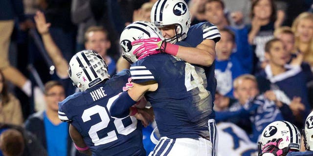 Oct 25, 2013; Provo, UT, USA; Brigham Young Cougars running back Adam Hine (28) and quarterback Taysom Hill (4) celebrate a touchdown by wide receiver Mitch Mathews (10) during the second half at Lavell Edwards Stadium. Brigham Young won 37-20. Mandatory Credit: Russ Isabella-USA TODAY Sports