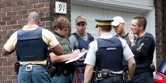 Aug. 25: Police talk outside of a home in the west end of Ottawa, Canada, after police arrested two Ottawa residents on terror-related charges.