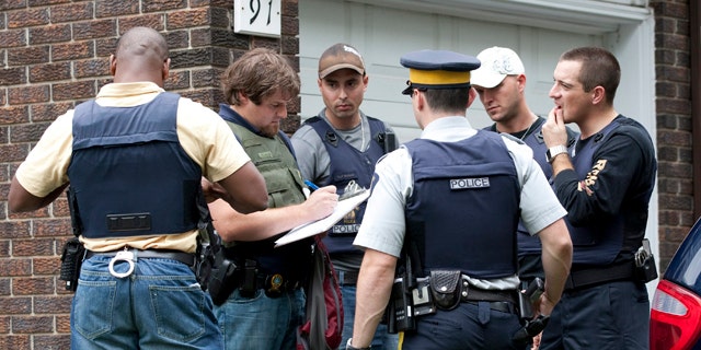 Aug. 25: Police talk outside of a home in the west end of Ottawa, Canada, after police arrested two Ottawa residents on terror-related charges.