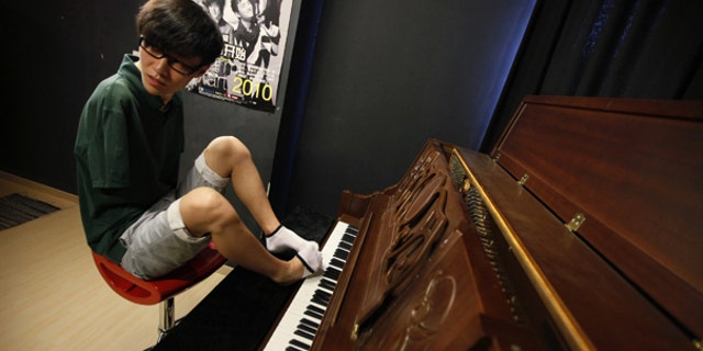 Aug. 26: Pianist Liu Wei takes off one of his socks to play piano in Shanghai. The 23-year-old's arms were amputated after a childhood accident.