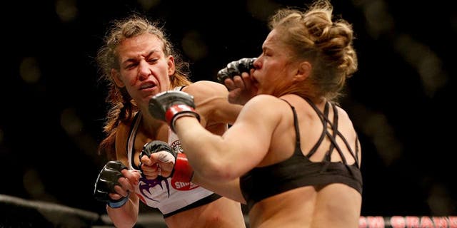 LAS VEGAS, NV - DECEMBER 28: (L-R) Miesha Tate punches Ronda Rousey in their UFC women's bantamweight championship bout during the UFC 168 event at the MGM Grand Garden Arena on December 28, 2013 in Las Vegas, Nevada. (Photo by Josh Hedges/Zuffa LLC/Zuffa LLC via Getty Images)
