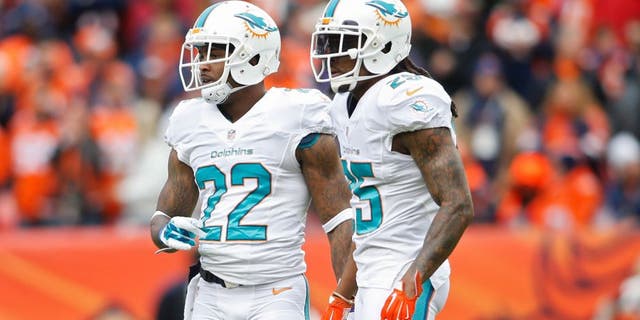 Nov 23, 2014; Denver, CO, USA; Miami Dolphins cornerback Jamar Taylor (22) and Miami Dolphins free safety Louis Delmas (25) during the game against the Denver Broncos at Sports Authority Field at Mile High. Mandatory Credit: Chris Humphreys-USA TODAY Sports