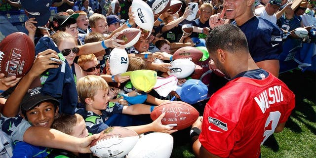 Jul 31, 2015; Renton, WA, USA; Seattle Seahawks quarterback Russell Wilson (3) and tight end Jimmy Graham (88) sign autographs following training camp practice at Virginia Mason Athletic Center. Mandatory Credit: Joe Nicholson-USA TODAY Sports