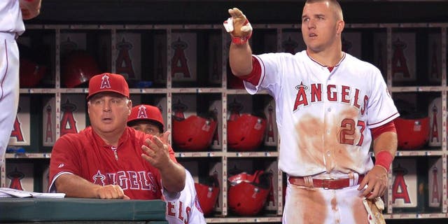 Aug 26, 2014; Anaheim, CA, USA; Los Angeles Angels third baseman David Freese (6) heads to the dugout after scoring on Los Angeles Angels left fielder Efren Navarro (19) single in the 4th inning against the Miami Marlins at Angel Stadium of Anaheim. Los Angeles Angels manager Mike Scioscia (14) and Los Angeles Angels center fielder Mike Trout (27) greet Freese. Mandatory Credit: Robert Hanashiro-USA TODAY Sports