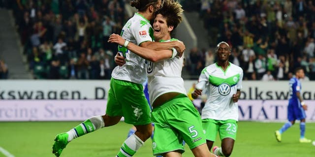 Wolfsburg's Swiss defender Timm Klose (R) celebrates with Wolfsburg's Swiss defender Ricardo Rodriguez after Klose scored the third goal during the German first division Bundesliga football match VfL Wolfsburg vs FC Schalke 04 in Wolfsburg, northern Germany, on August 28, 2015. AFP PHOTO / JOHN MACDOUGALL RESTRICTIONS: DURING MATCH TIME: DFL RULES TO LIMIT THE ONLINE USAGE TO 15 PICTURES PER MATCH AND FORBID IMAGE SEQUENCES TO SIMULATE VIDEO. == RESTRICTED TO EDITORIAL USE == FOR FURTHER QUERIES PLEASE CONTACT DFL DIRECTLY AT + 49 69 650050. (Photo credit should read JOHN MACDOUGALL/AFP/Getty Images)