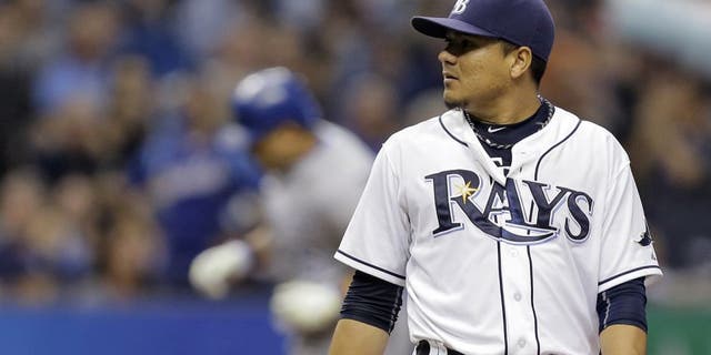 Tampa Bay Rays starting pitcher Erasmo Ramirez, foreground, looks at the home plate umpire as Kansas City Royals' Kendrys Morales runs the bases after hitting a two-run home run during the third inning of a baseball game Friday, Aug. 28, 2015, in St. Petersburg, Fla. (AP Photo/Chris O'Meara)