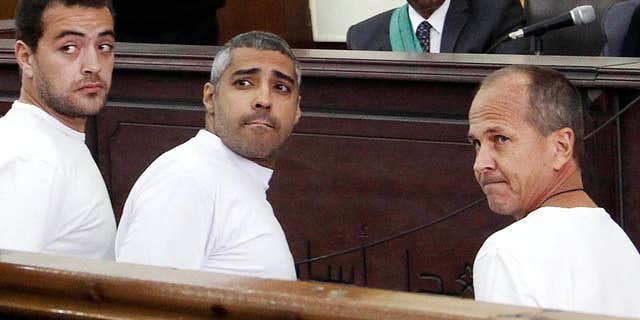 March 31, 2014: Al-Jazeera English producer Baher Mohamed, left, Canadian-Egyptian acting Cairo bureau chief Mohammed Fahmy, center, and correspondent Peter Greste, right, appear in court along with several other defendants during their trial on terror charges, in Cairo.